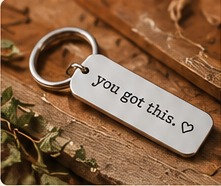 An engraved you got this keychain on a wooden table